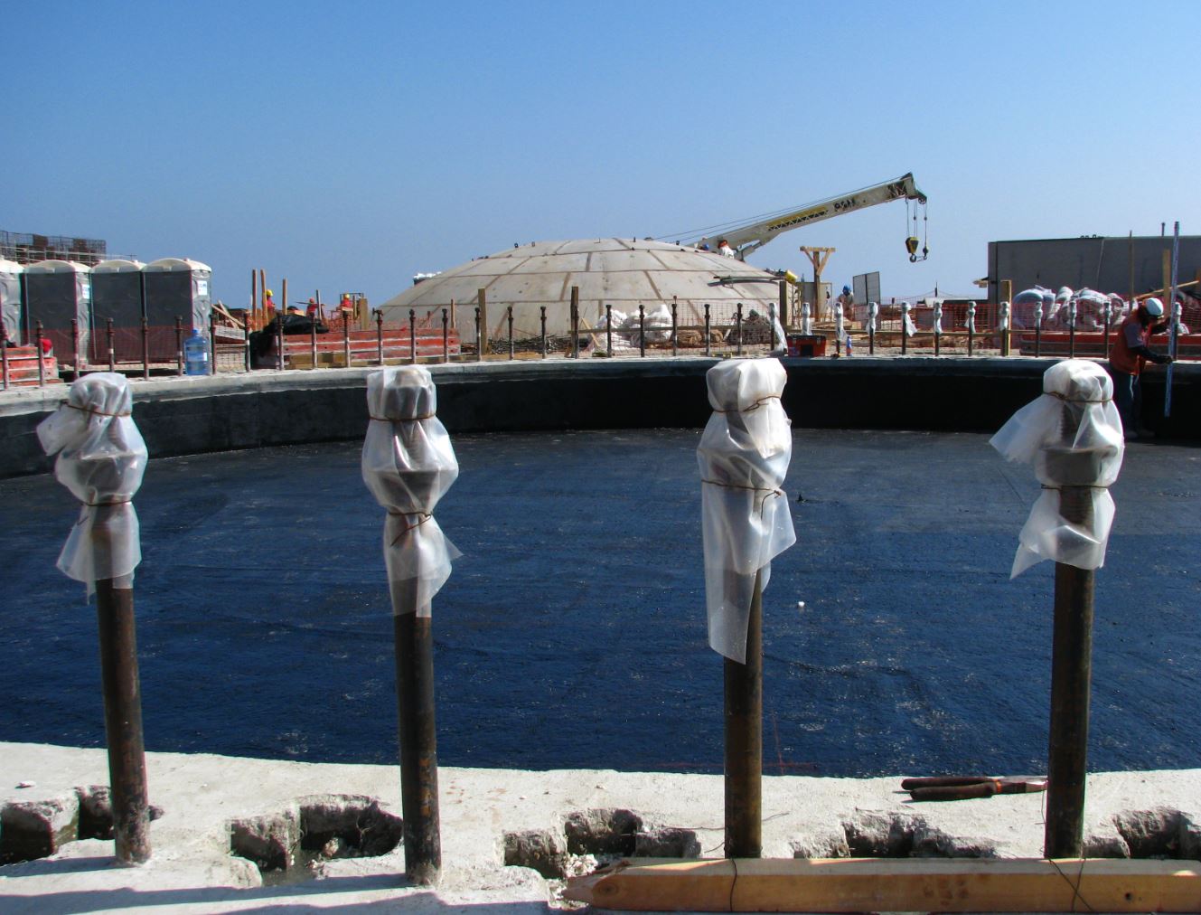 Obra en construcción con grúa y estructura circular de hormigón